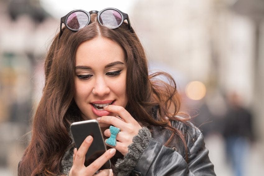 intrigued woman reading text outside
