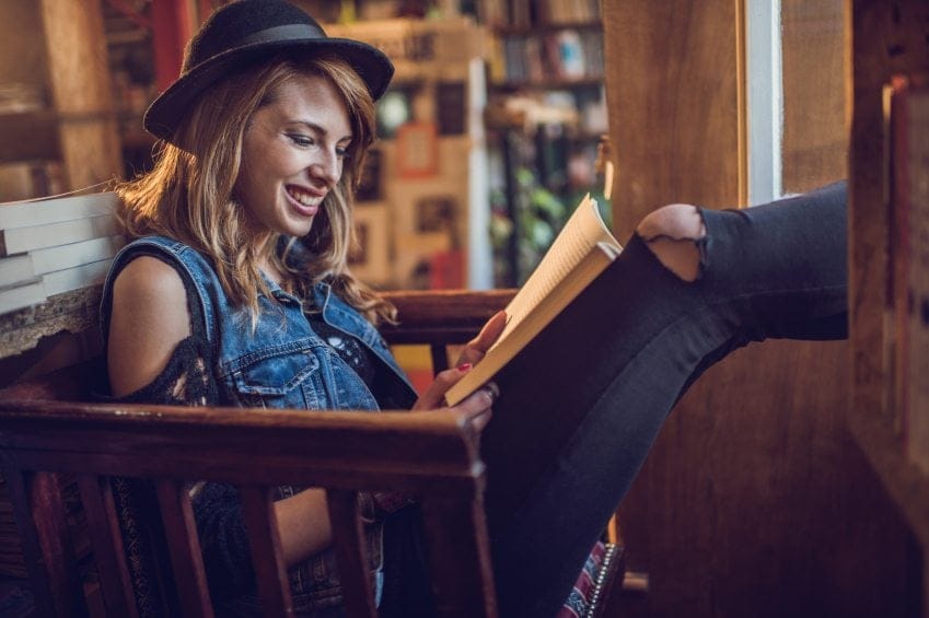 happy woman reading at bookstore