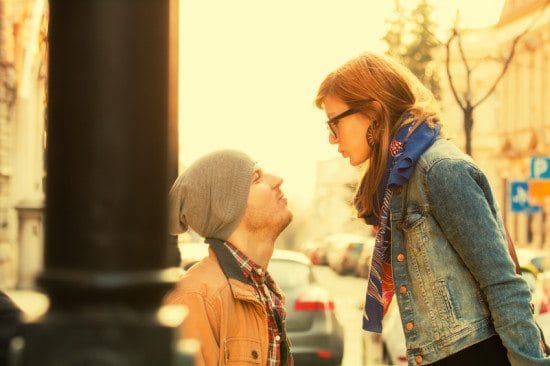 couple puckering lips in city