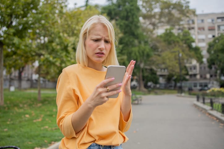 annoyed woman texting in park