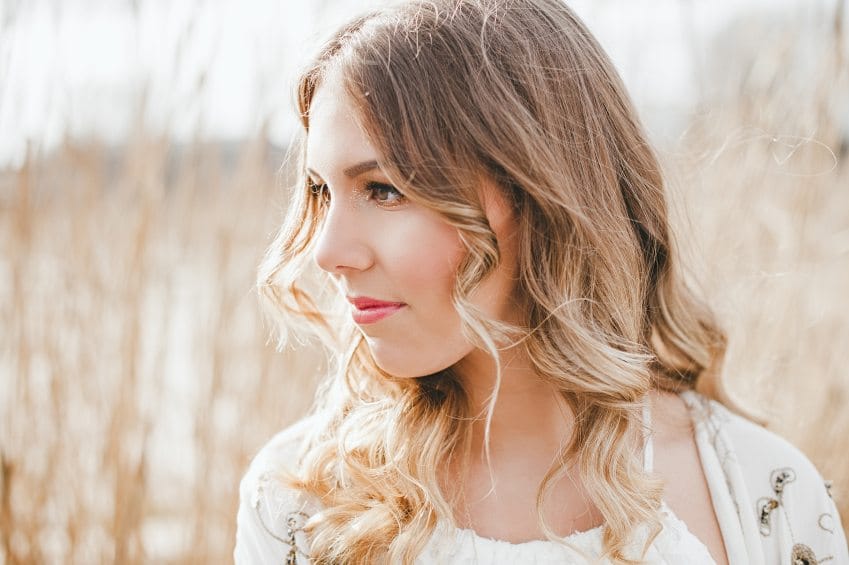 Woman looking serious standing outside.