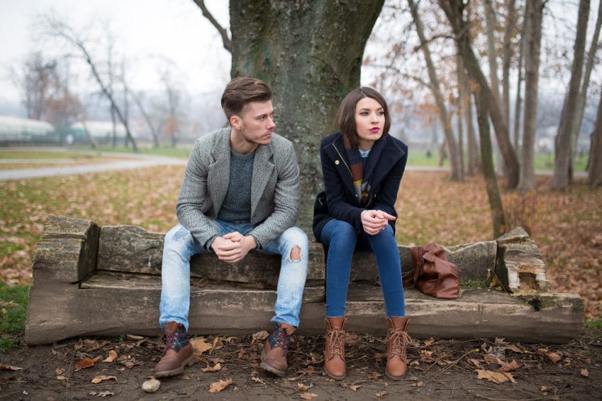Unhappy couple arguing at local park.