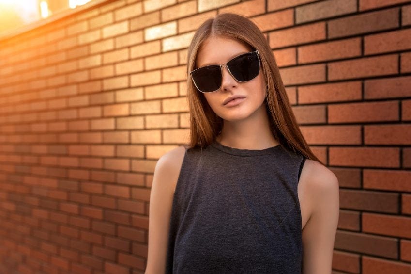 Portrait of Young Woman on Brick Wall Background.