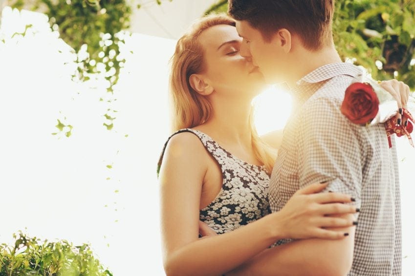 Young couple hugging and kissing at sunset