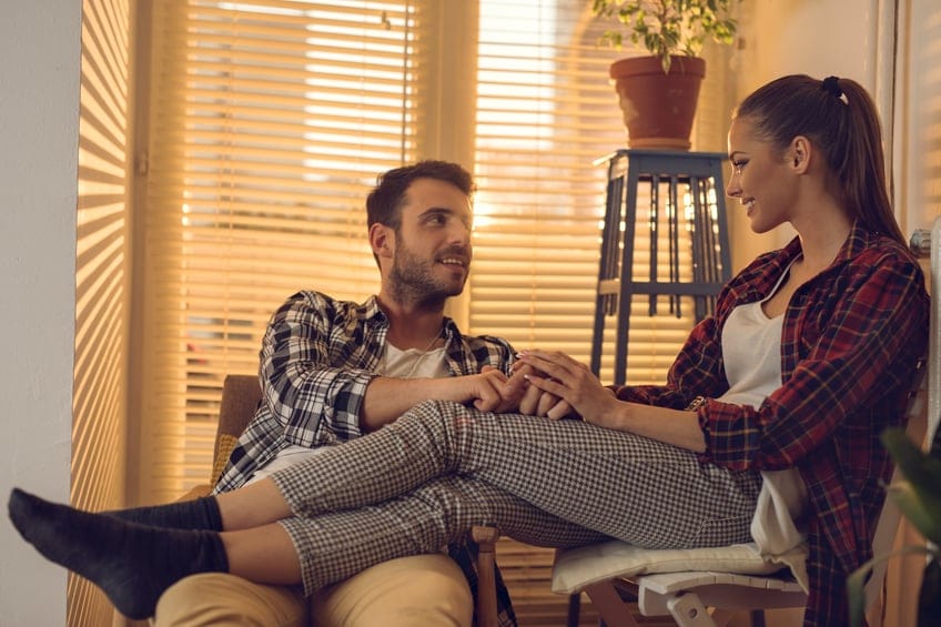 Relaxed couple sitting at home and talking to each other.