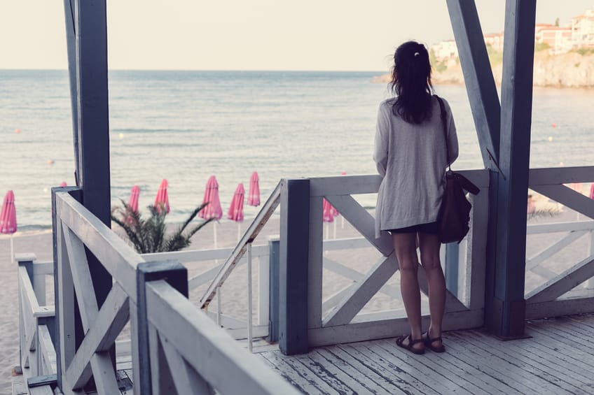 Rear view of woman standing at a veranda