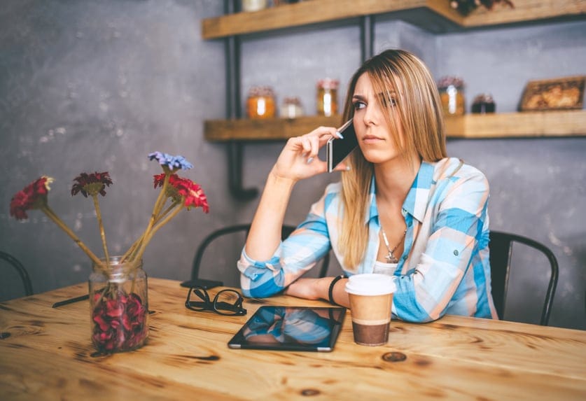 worried young woman talking on smartphone