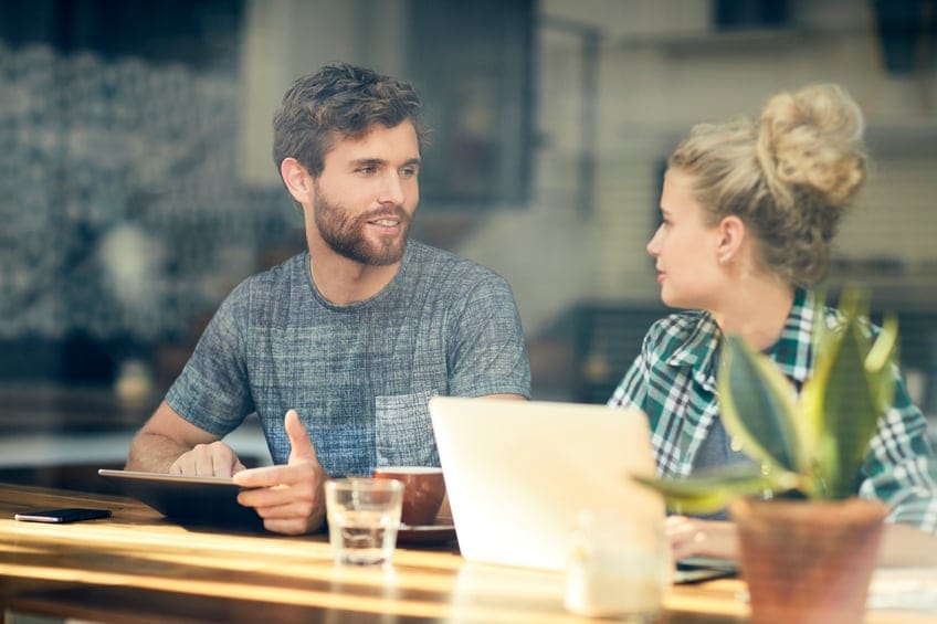 Man with digital tablet talking with woman