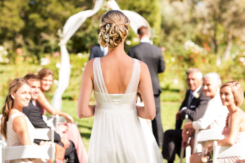 Rear view of young bride walking down the aisle