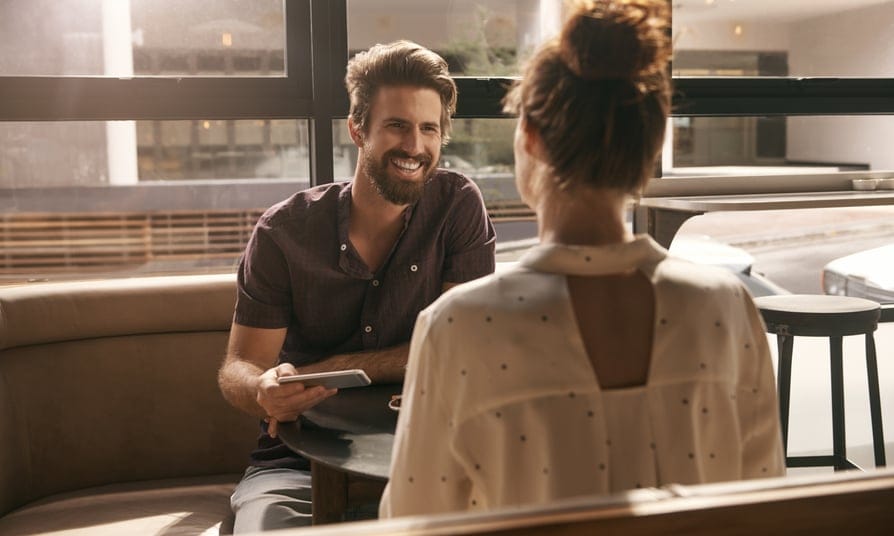 Young couple sat inside at table