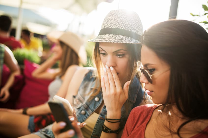 Shocked women reading a text message on mobile phone.