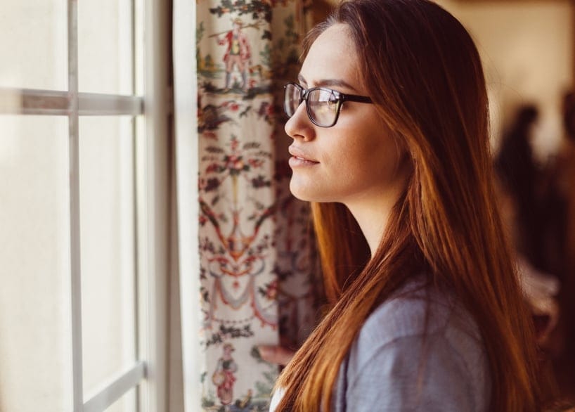 Young woman looking through the window