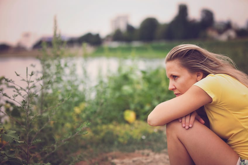 woman sad outside lake