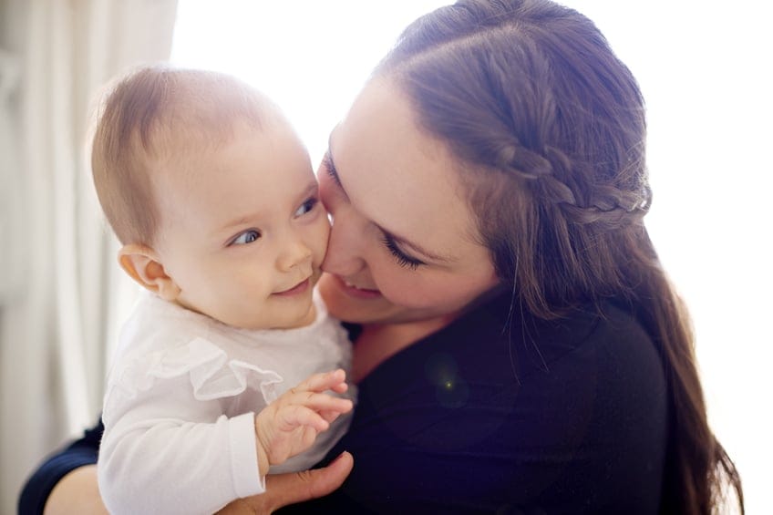woman holding baby smiling