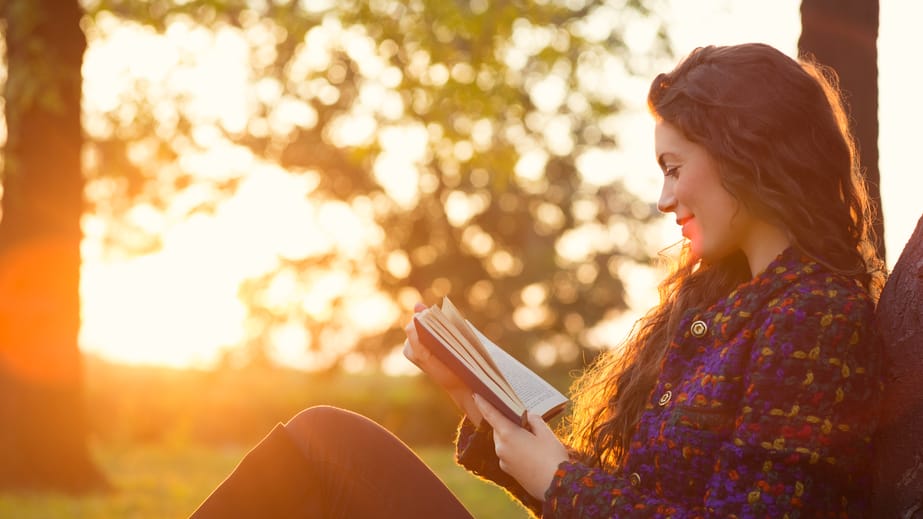 woman reading sunset autumn trees