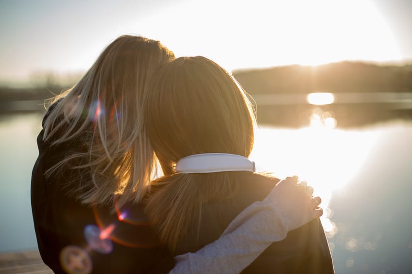 Two happy woman in the sunset on the lake