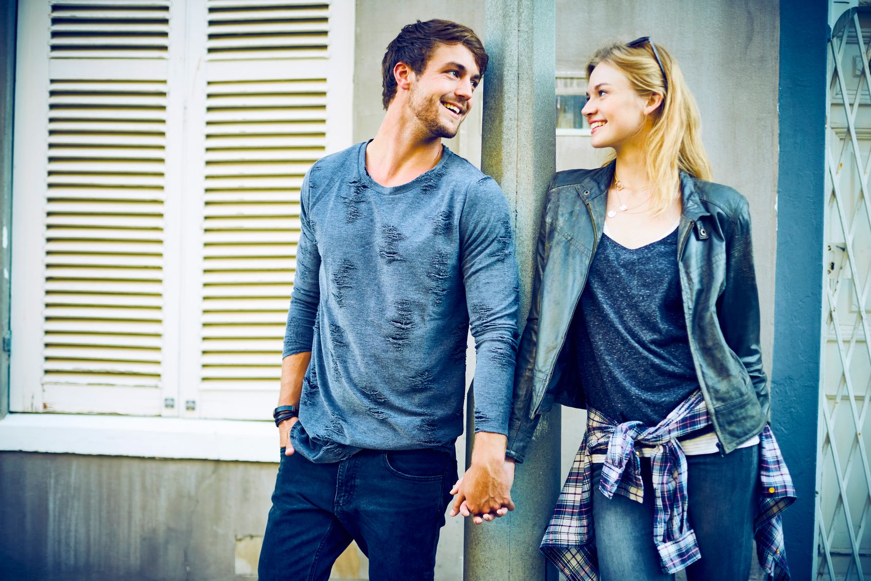Happy loving couple holding hands at pole