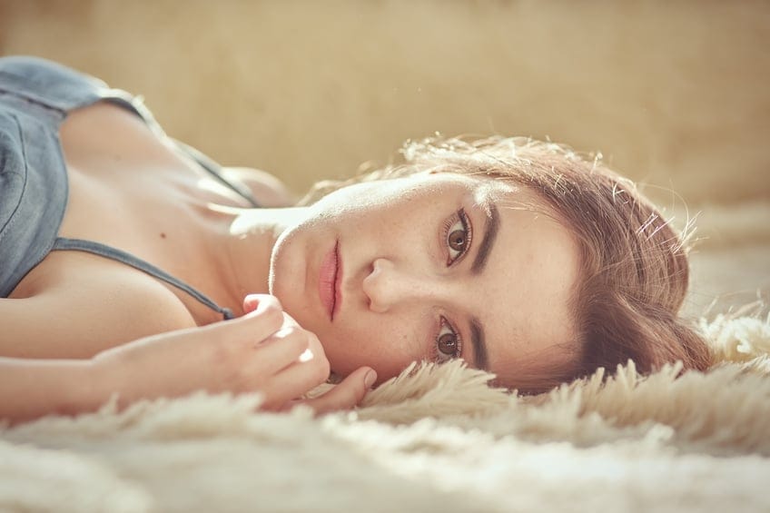 pensive girl lying looking at camera, toned image