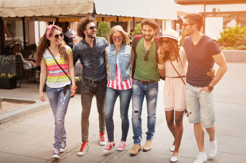 Friends having fun outdoors, walking down the street.