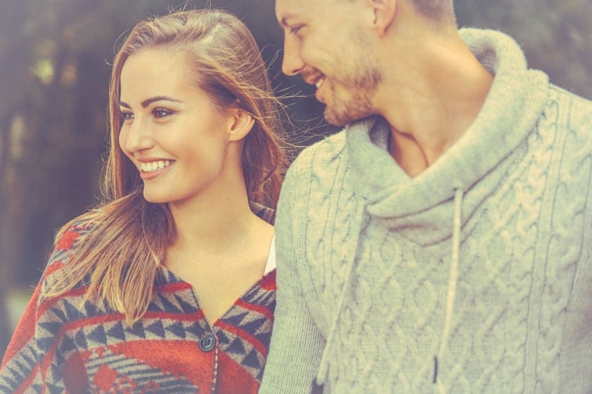 Young loving couple holding hands in stroll through the nature