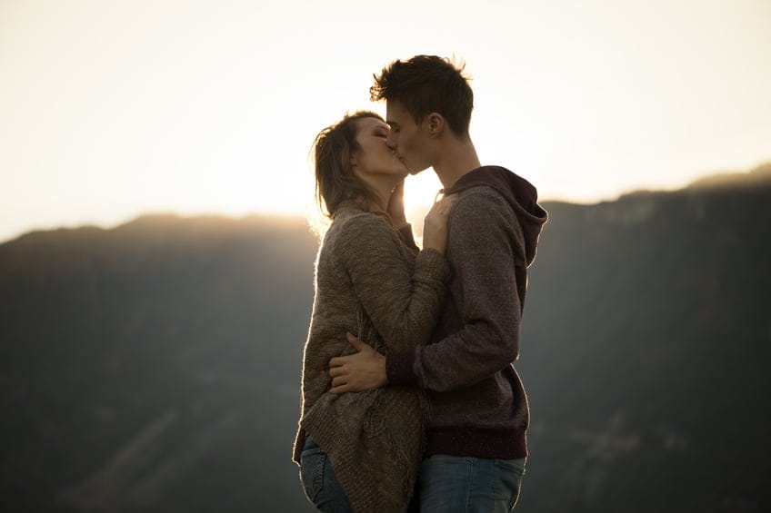 couple kissing outdoors sunset
