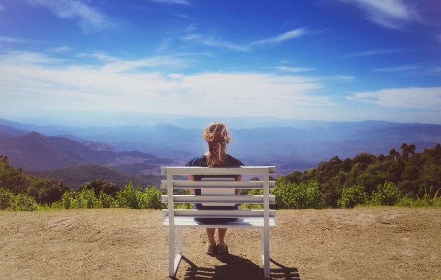 woman bench view mountain blue sky