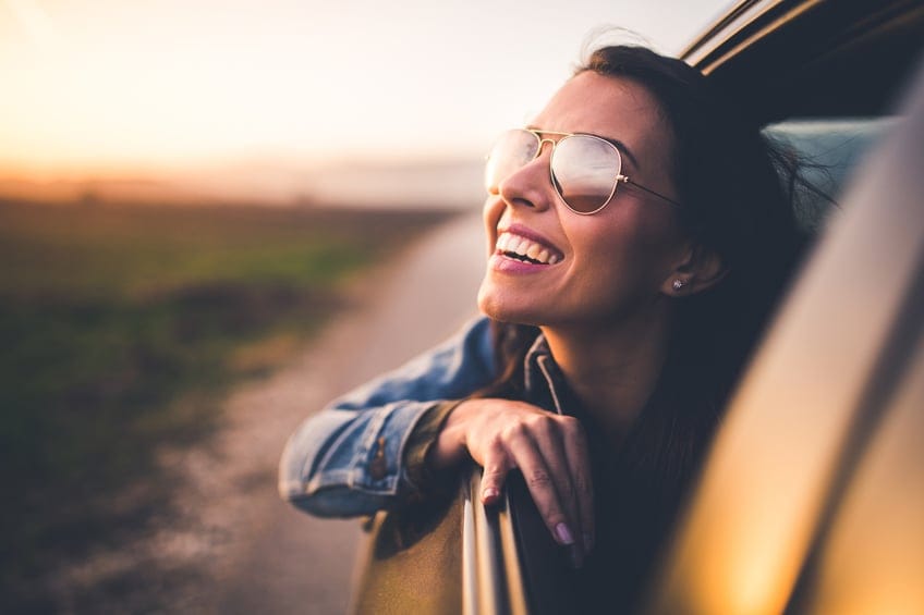 woman riding car sunshine sunglasses
