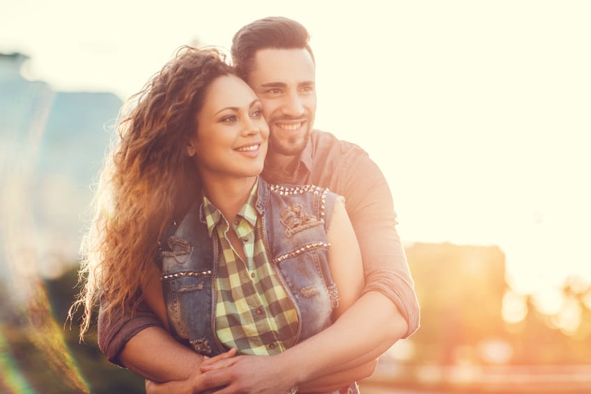 Happy young couple embracing at sunset