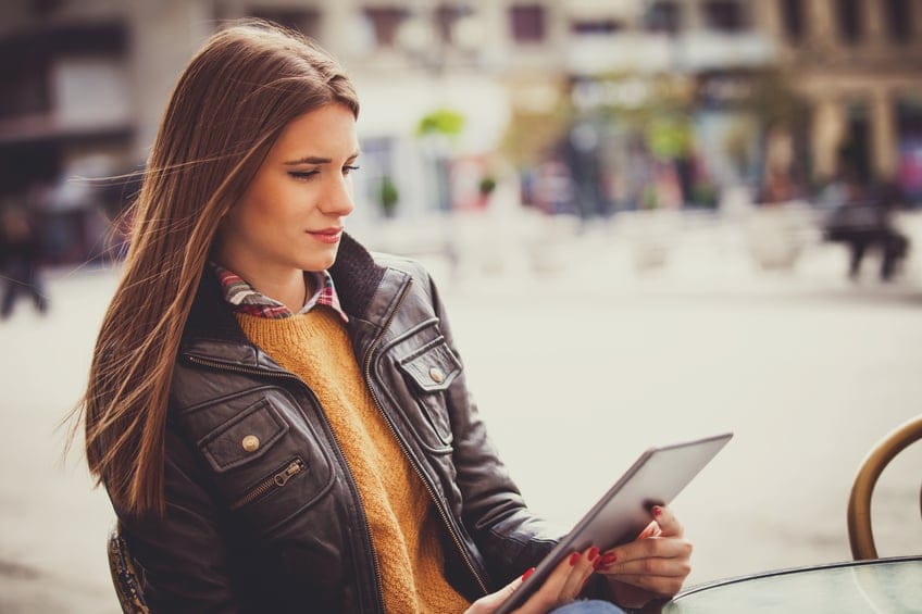 Young woman using digital tablet outside