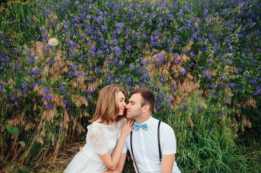 couple kissing field flowers romance