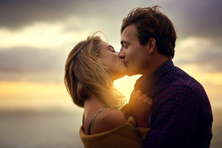 young couple kissing happy romance sunset