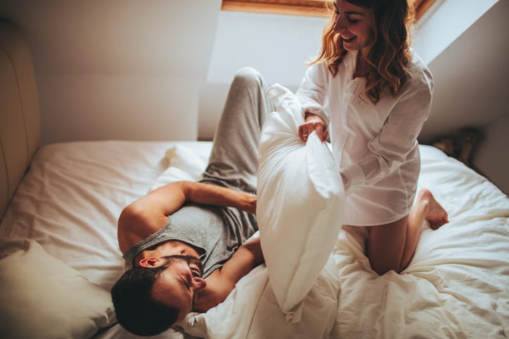 couple bed happy pillow fight romance