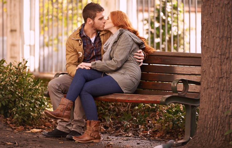 Shot of a happy young couple sharing an affectionate moment on a park bench