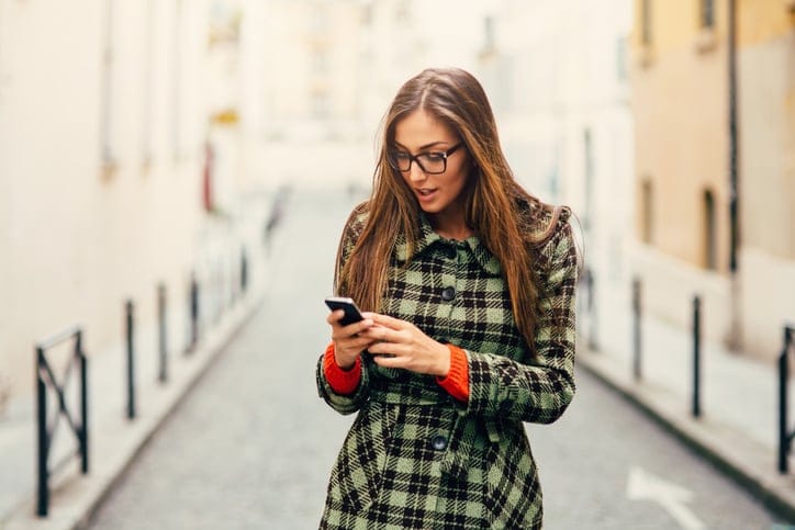 Beautiful woman texting outdoor in Paris.