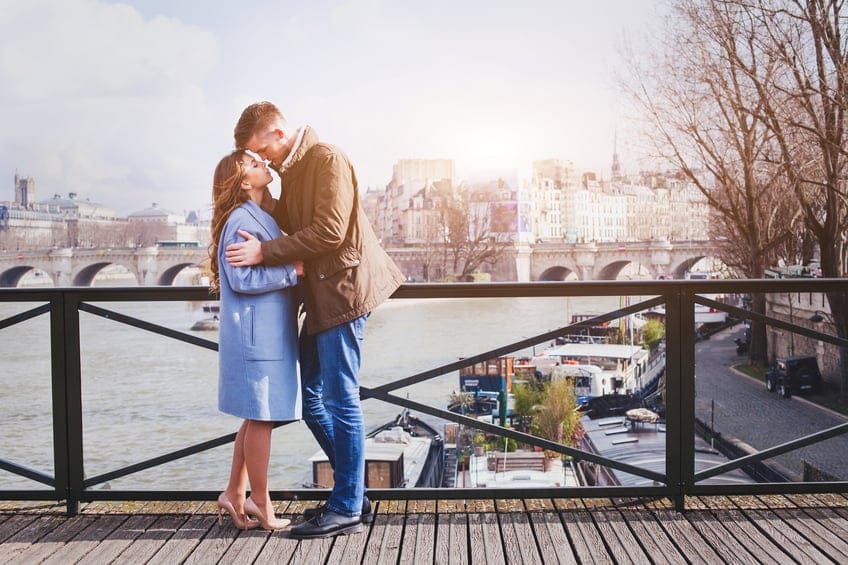 romantic date, young couple kissing on the bridge in Paris