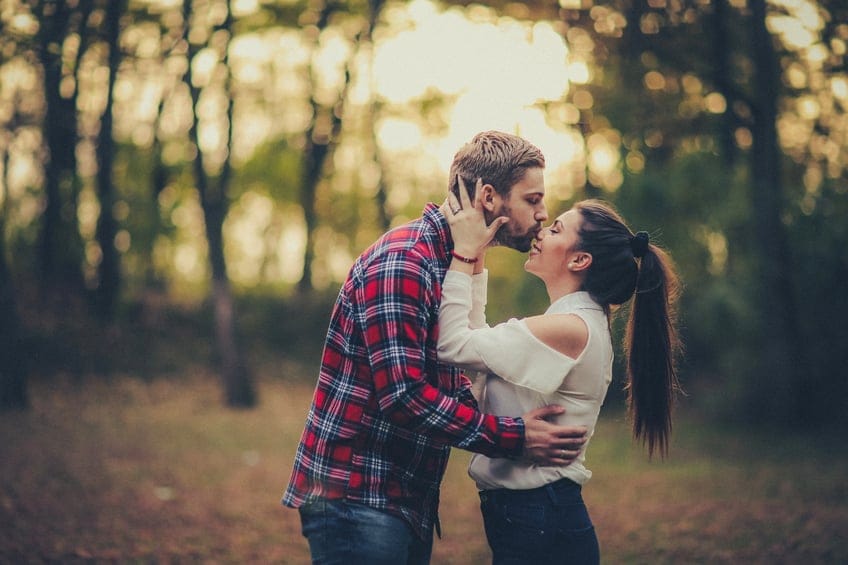 young couple kissing in the sunshine