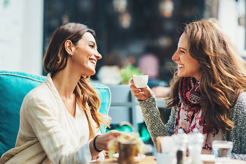 Young women drinking coffee and smiling