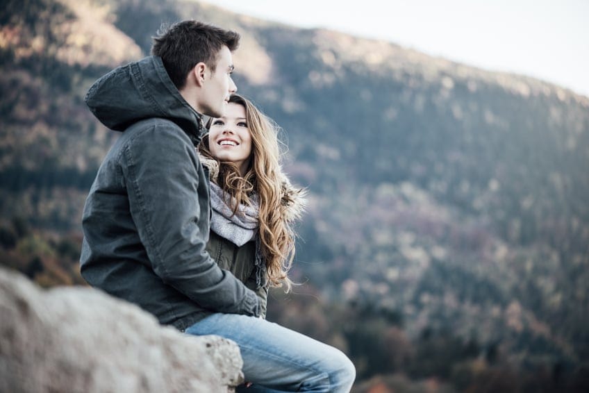 Couple sitting on a mountain top