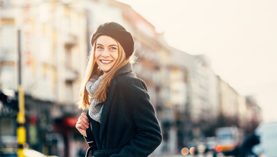 Happy woman walking dawn the street.