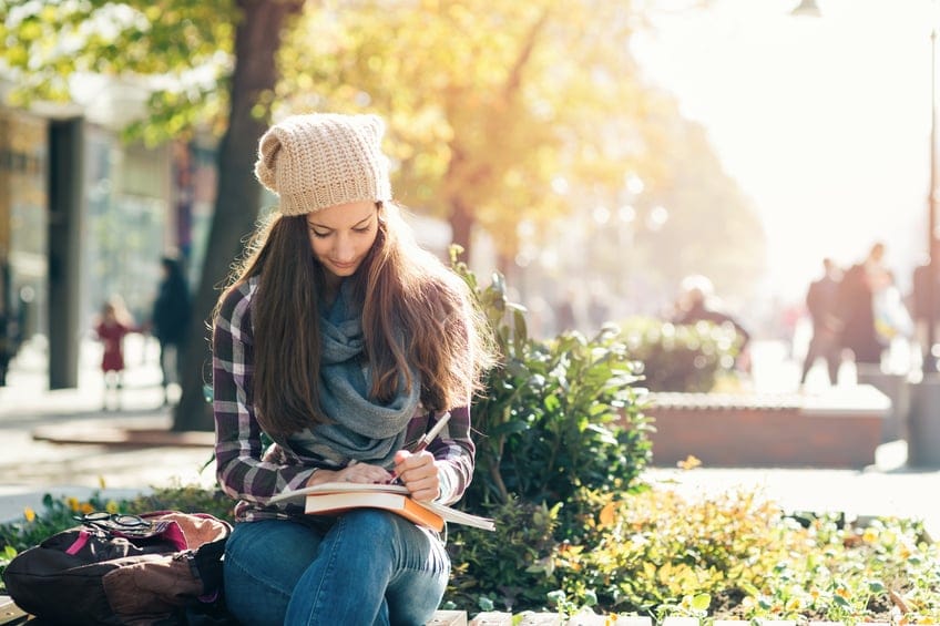 Girl writing in notebook and studying.