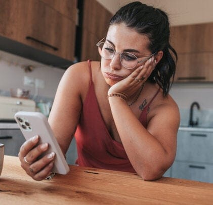 stressed woman in kitchen texting