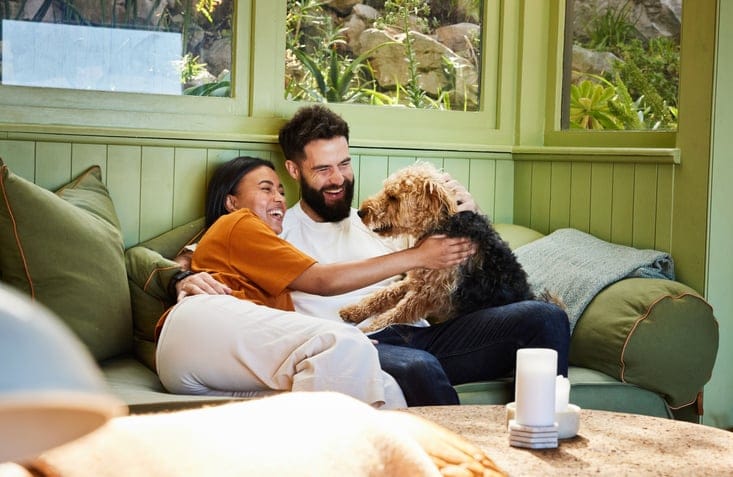 couple hanging out on couch with dog