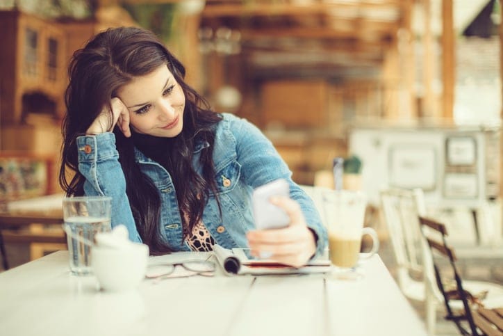 young woman cafe texting phone
