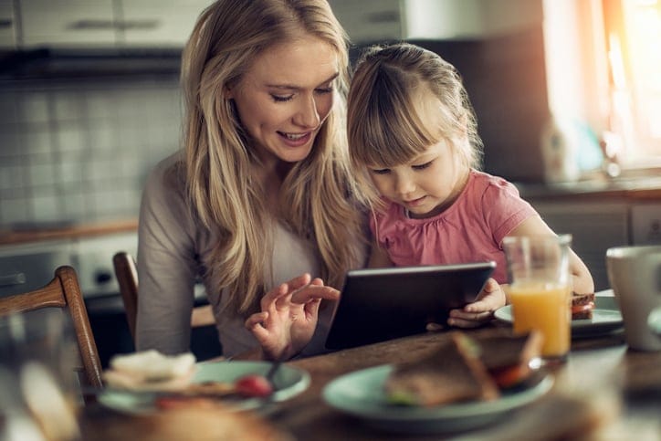 Picture of a mother and daughter having breakfast and surfing the net