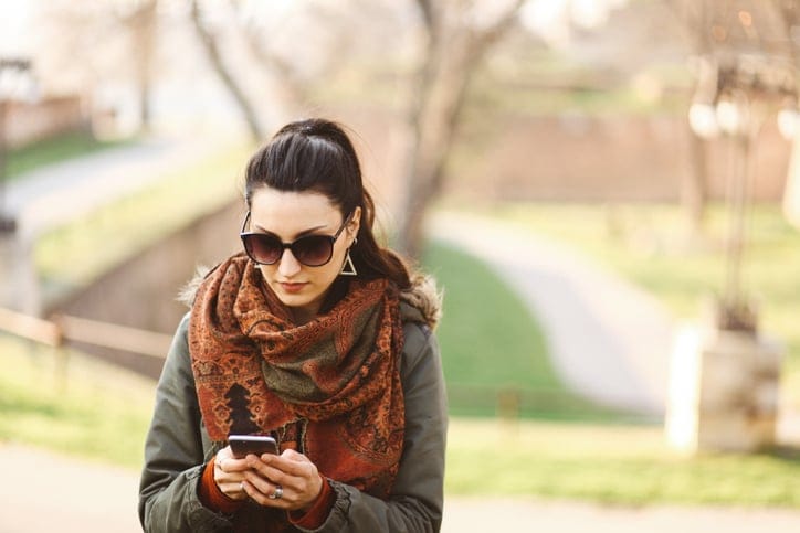 woman texting outdoors autumn