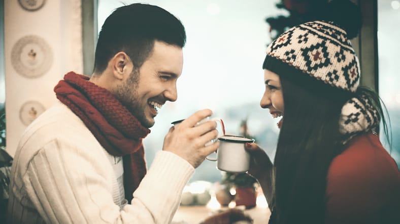 couple in winter clothes drinking something hot