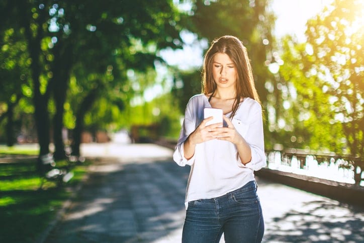fashionable atractive young woman using smartphone in the street