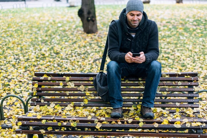 Man sitting alone on a park bench.