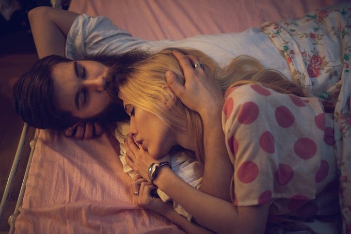 High angle view of loving couple in bed