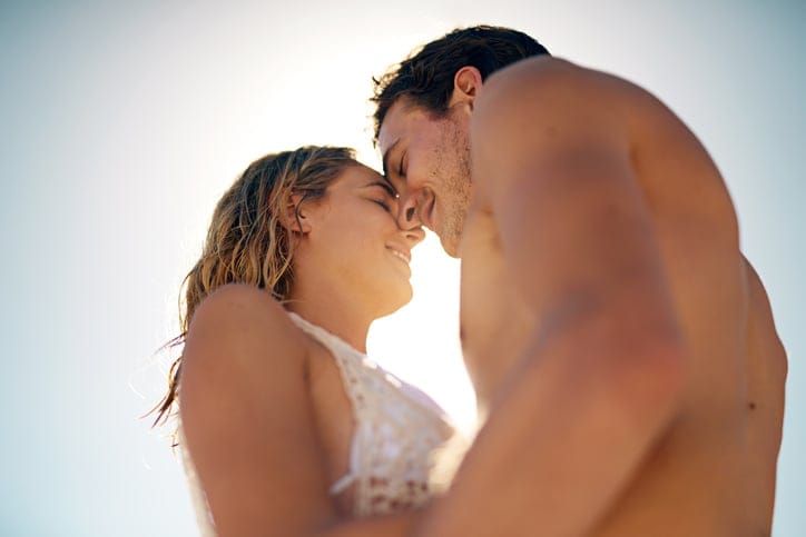 young couple kissing beach romantic